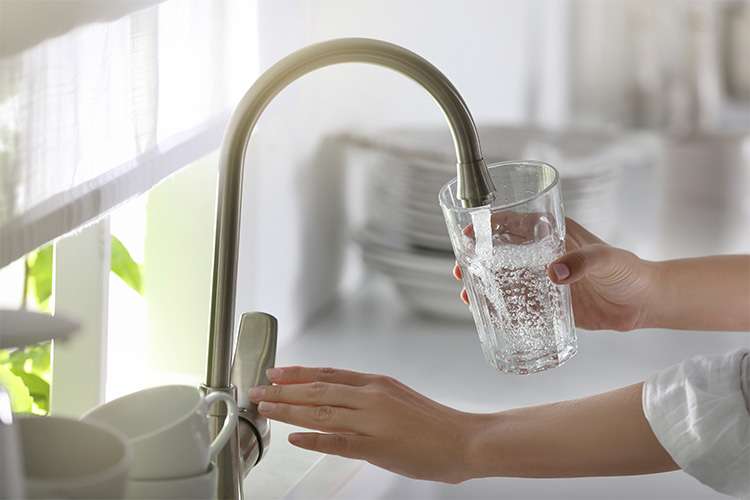 woman getting water from a sink.